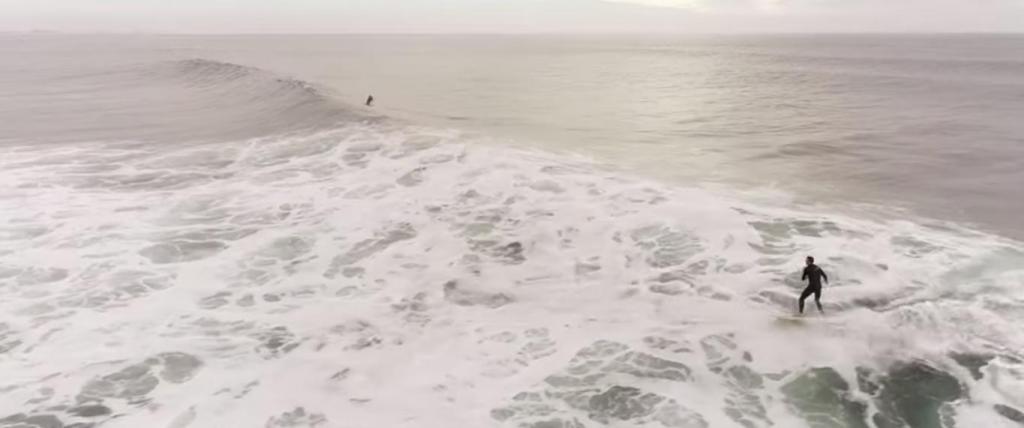 Летящий дрон заснял, как дельфины догнали серфингиста и стали прыгать с ним по волнам (видео)