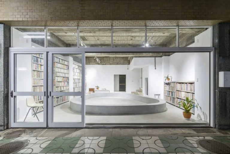 Архитекторы построили бетонный дом с открытой библиотекой на 1-м этаже: а похожая на бассейн скамейка в центре воссоздает атмосферу городской площади (фото)