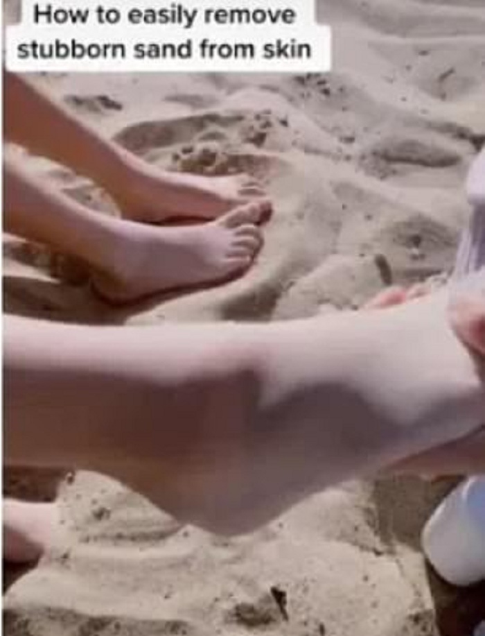 Мама показывает хитрый трюк для того, чтобы смыть песок с рук и ног после целого дня на пляже