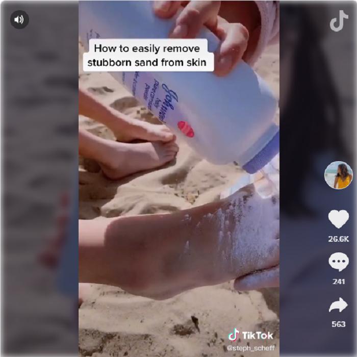 Мама показывает хитрый трюк для того, чтобы смыть песок с рук и ног после целого дня на пляже