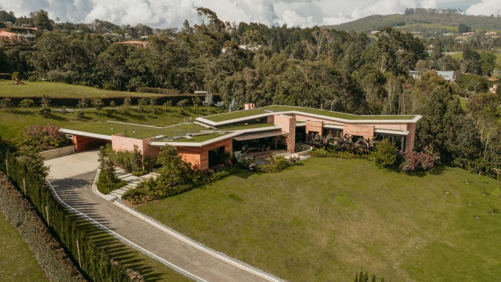 Живые зеленые крыши домов сливаются с холмом и лесом в Колумбии
