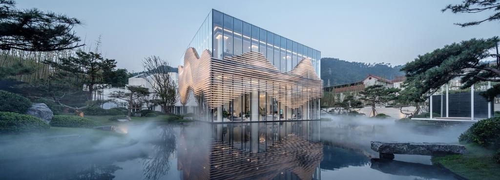 Дизайнеры окружили торговый павильон в Китае эфирным туманом и волнообразными пластинами в качестве жалюзи. Кажется, будто здание парит в облаках