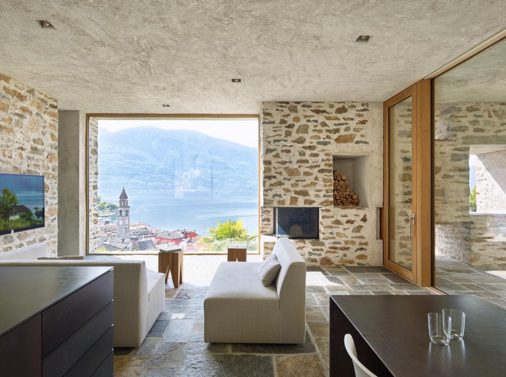 С помощью натурального камня и традиционной для Швейцарии штукатурки дизайнеры умело интегрировали дом в окрестности