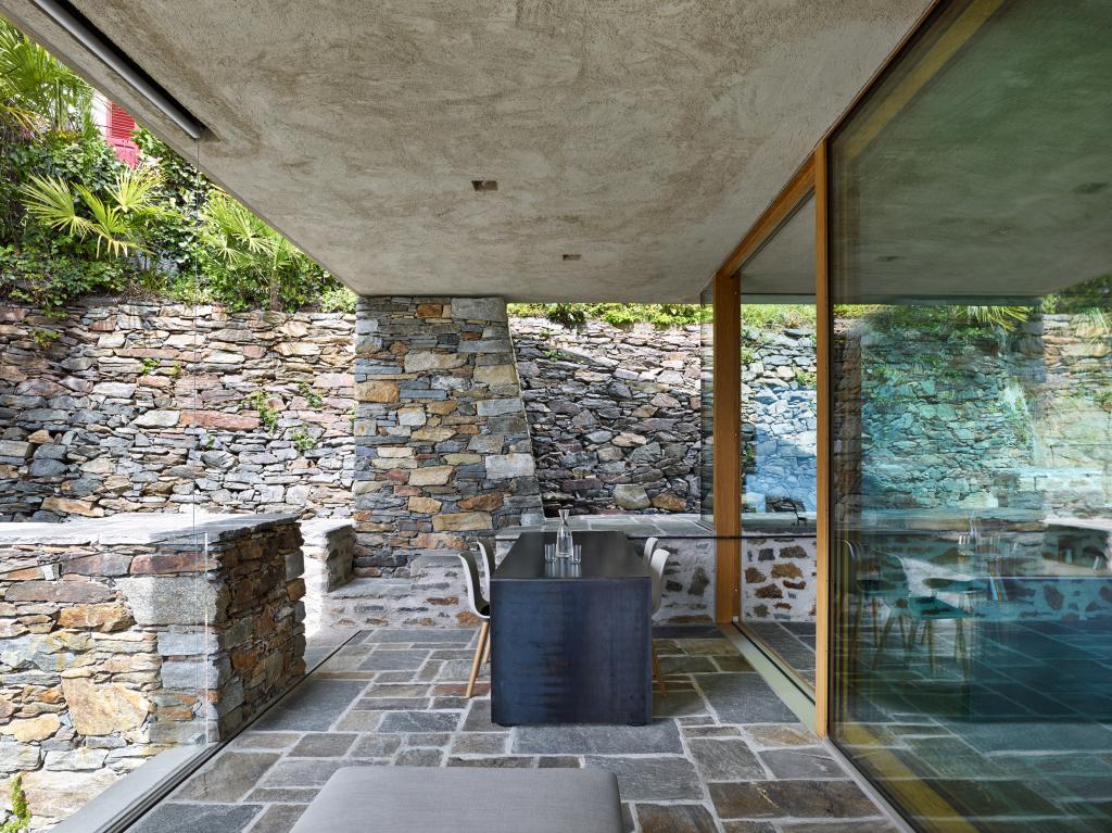 С помощью натурального камня и традиционной для Швейцарии штукатурки дизайнеры умело интегрировали дом в окрестности