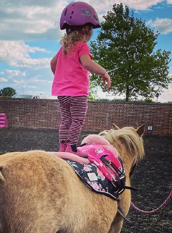 Маленькая наездница катается на своем пони, словно настоящий профессионал: а ведь ей всего 2 года