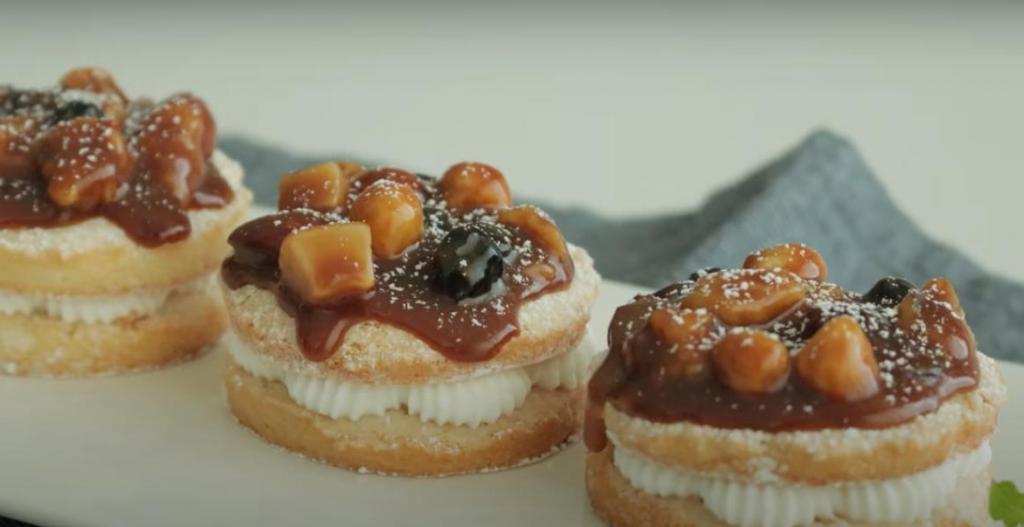 Вместо обычных пончиков можно приготовить изысканный десерт с воздушным кремом, карамелью и орехами: вкусно и очень празднично