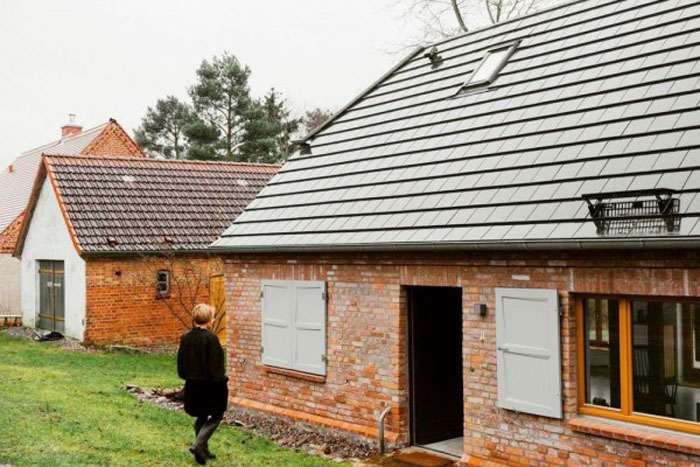 Акцент вокруг двери и в сочетании с железной крышей: шесть проектов домов с кирпичными стенами