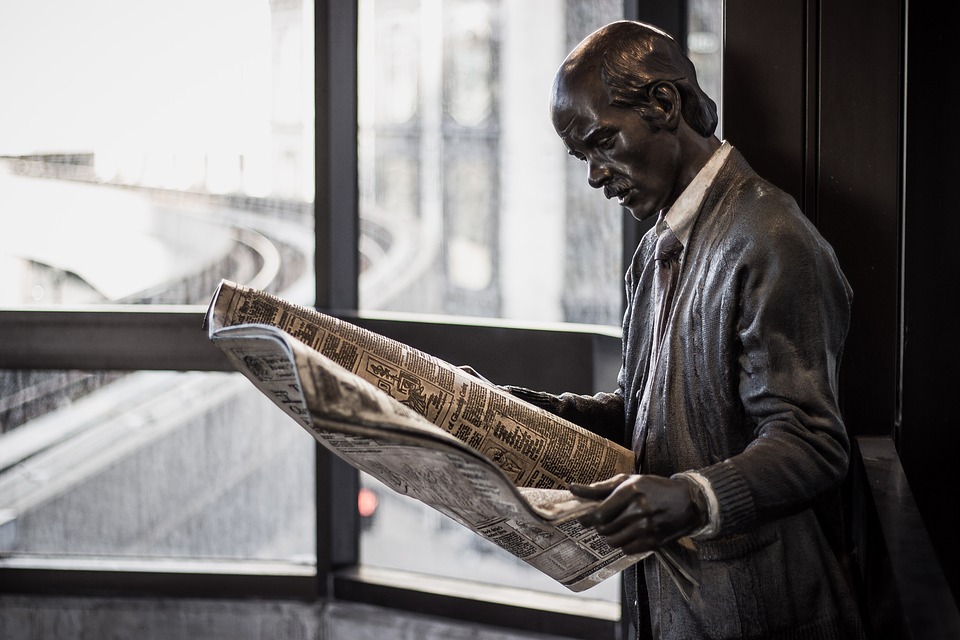 Статуя читающего газету человека