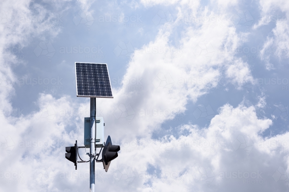 Светофор на солнечной батарее на фоне неба