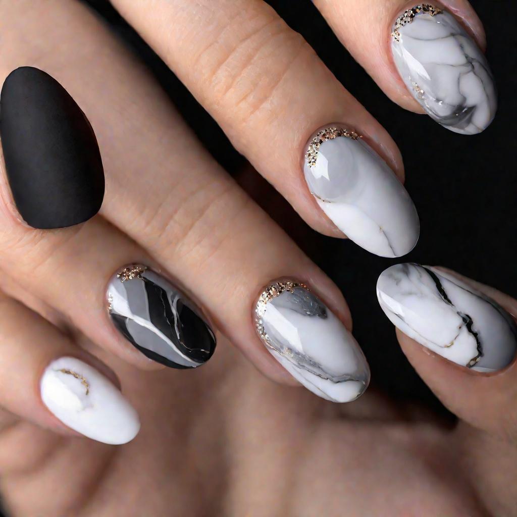 Крупный кадр стильных коротких закругленных ногтей с мраморным дизайном в оттенках серого и белого на черном фоне. Ногти освещены мягким светом, чтобы подчеркнуть изысканность мраморной текстуры.