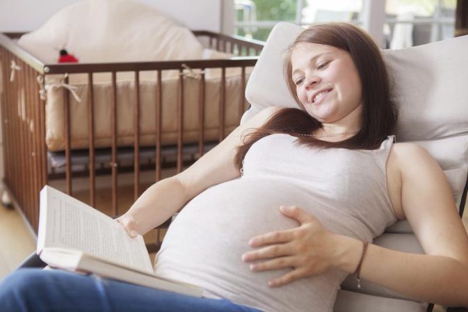 беременная женщина читает книгу
