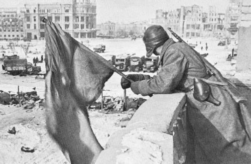 Советский солдат с красным знаменем на руинах одного из зданий Сталинграда