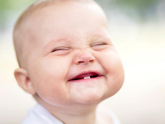 Малыш показывает первые зубки