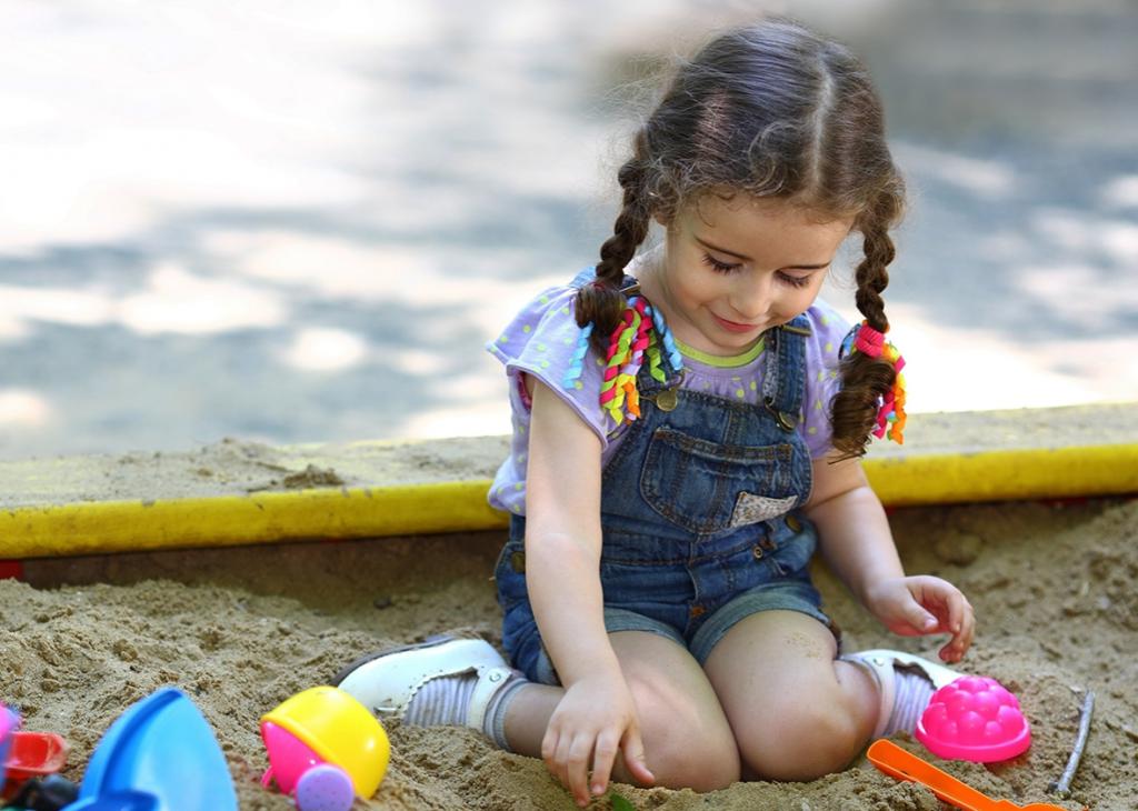 девочка играет в песочнице