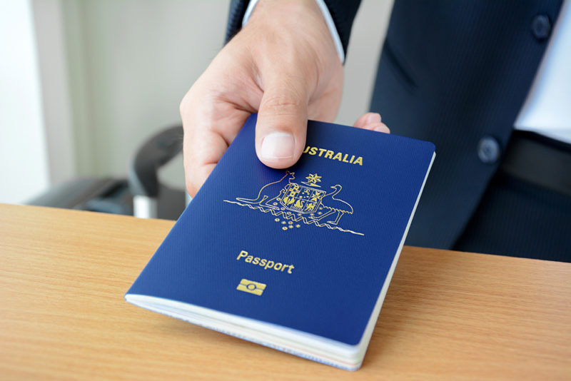 мужчина держит австралийский паспорт