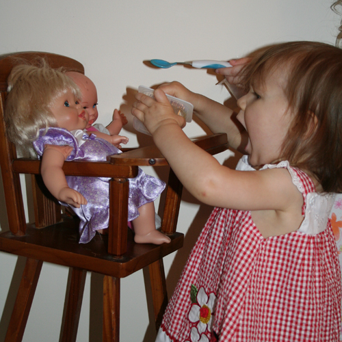 девочка кормит кукол