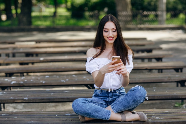 Девушка переписывается и улыбается