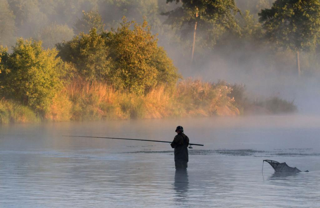 Мужчина рыбачит в тумане.