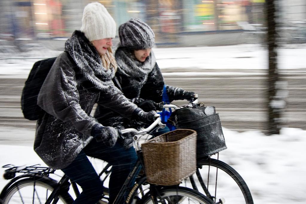 Девушки попали под снегопад на велосипедах.
