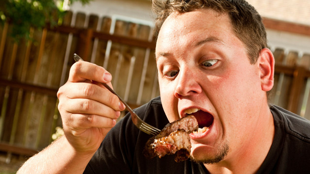 Мужчина ест мясо