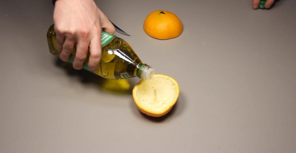 Свечка в апельсиновой кожуре в руках. Разлитое масло авокадо. Наливаем масло на сковородку. Чистящее средство из апельсиновых корок и уксуса.