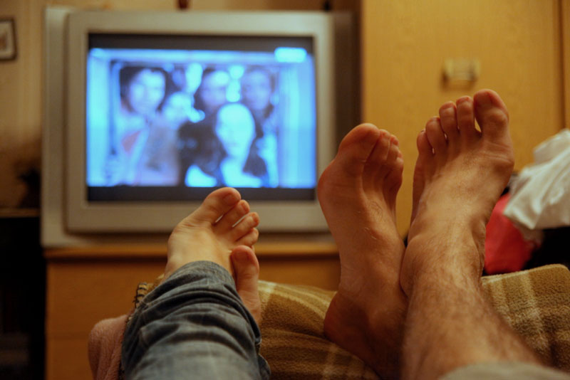 Почему смотрят на ноги. Ноги перед телевизором. Нога для телевизора. Коги перед телефвищором. Пара перед телевизором.