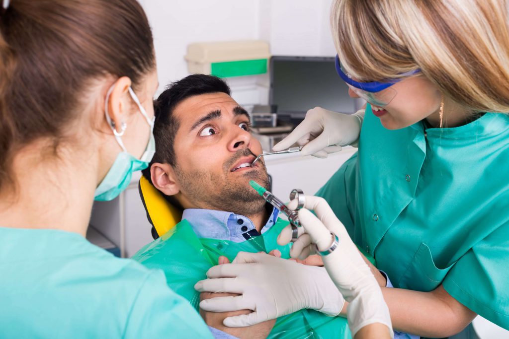 Врач который делает зубы. Человек на приеме у стоматолога. Пациент в стоматологии.