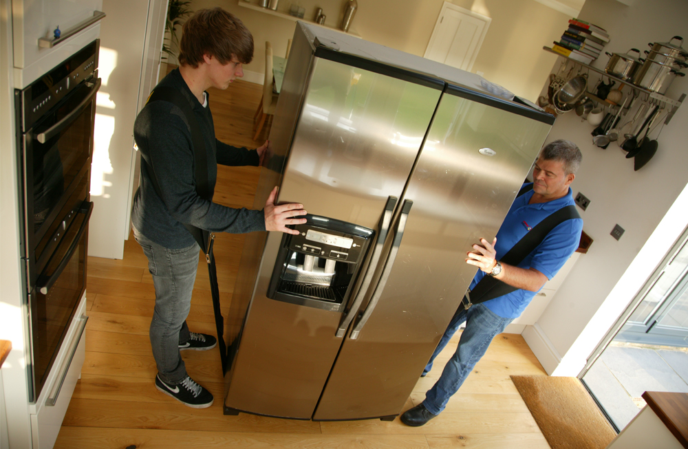 Холодильник после перевозки стоя. Огромный холодильник. Грузчик с холодильником. Перевоз холодильника. Бытовые холодильники.