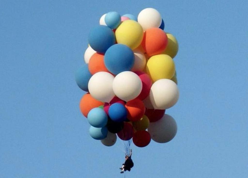 Воздушный шарик наполненный гелием взлетает в воздухе. Шары воздушные в воздухе. Человек взлетел на воздушных шарах. Шарики взлетают. Гелевый шар в воздухе.