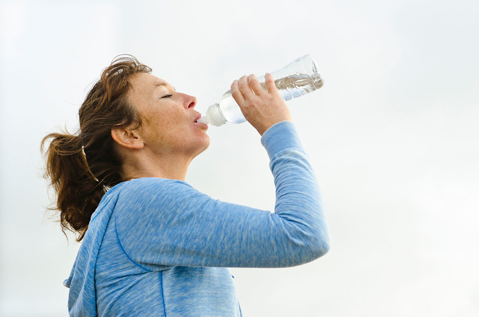 Женщина пьет. Вода против головной боли. Женщина пьет много воды. Пьет из 5 литровки. Пить воду во время месячных