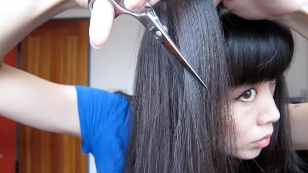Девушка сама стрижет волосы.