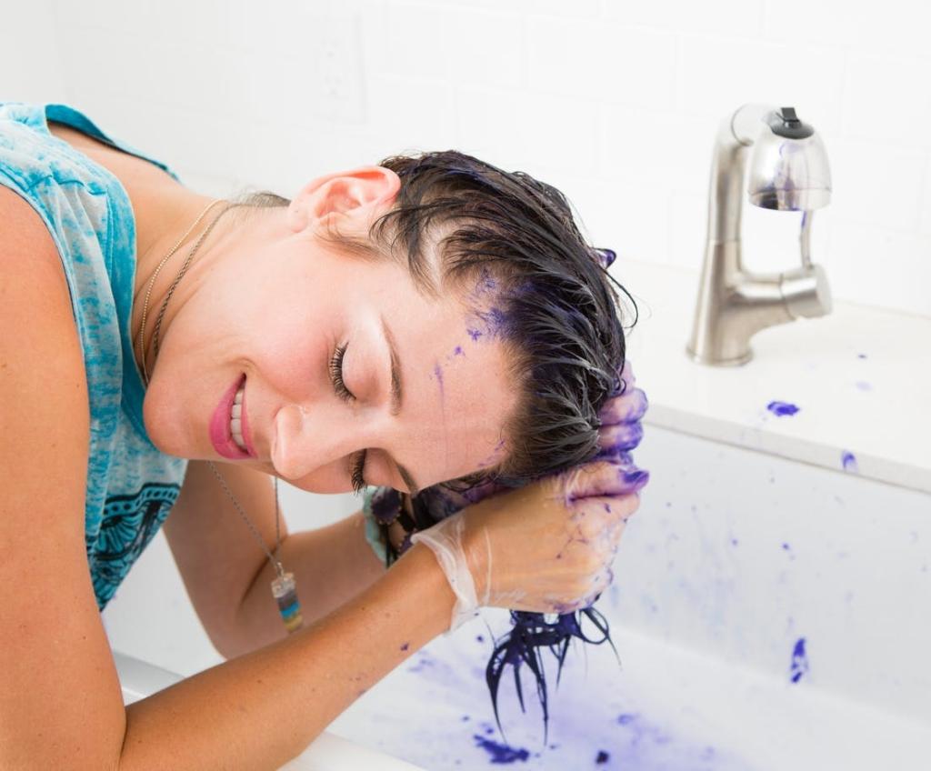 Мытье волос. Волосы в ванной. Смывание краски с волос. Девушка красит волосы.