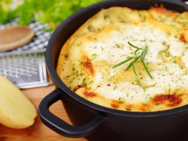 Oven baked potatoes with cheese and sour cream in the oven