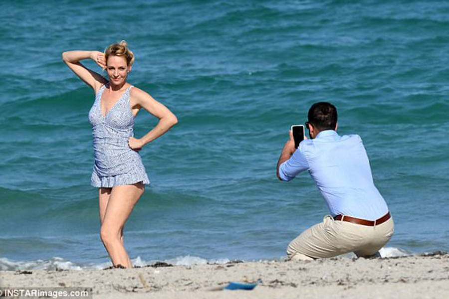 мужчина фотографирует женщину на пляже