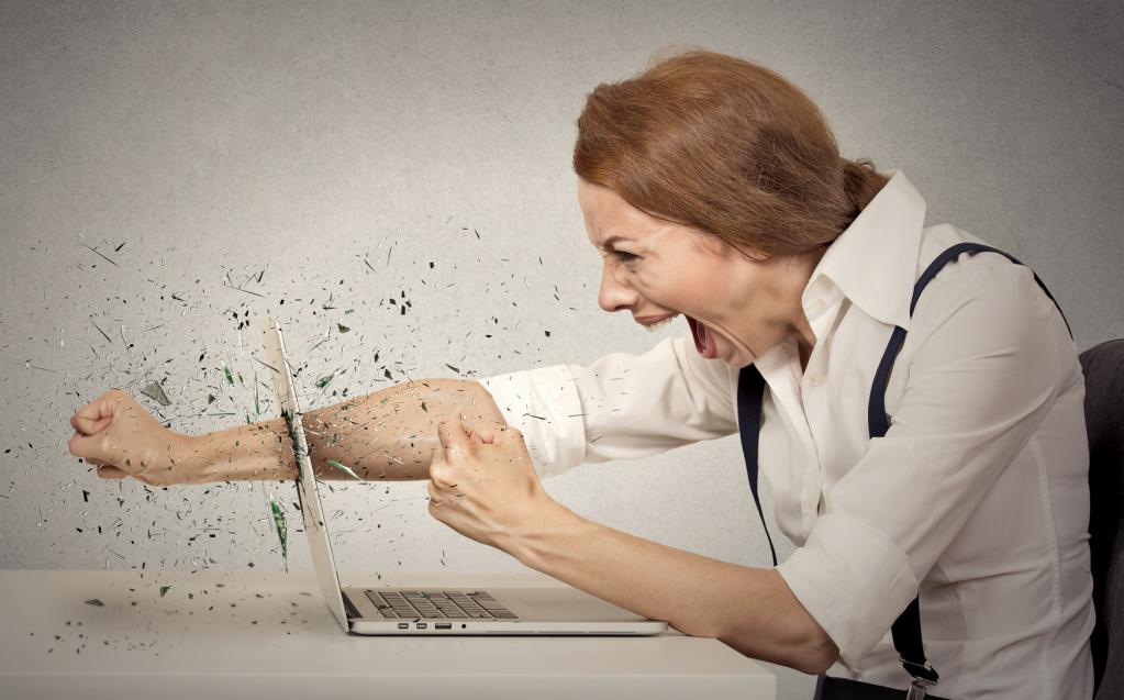 Женщина в гневе разбивает монитор ноутбука