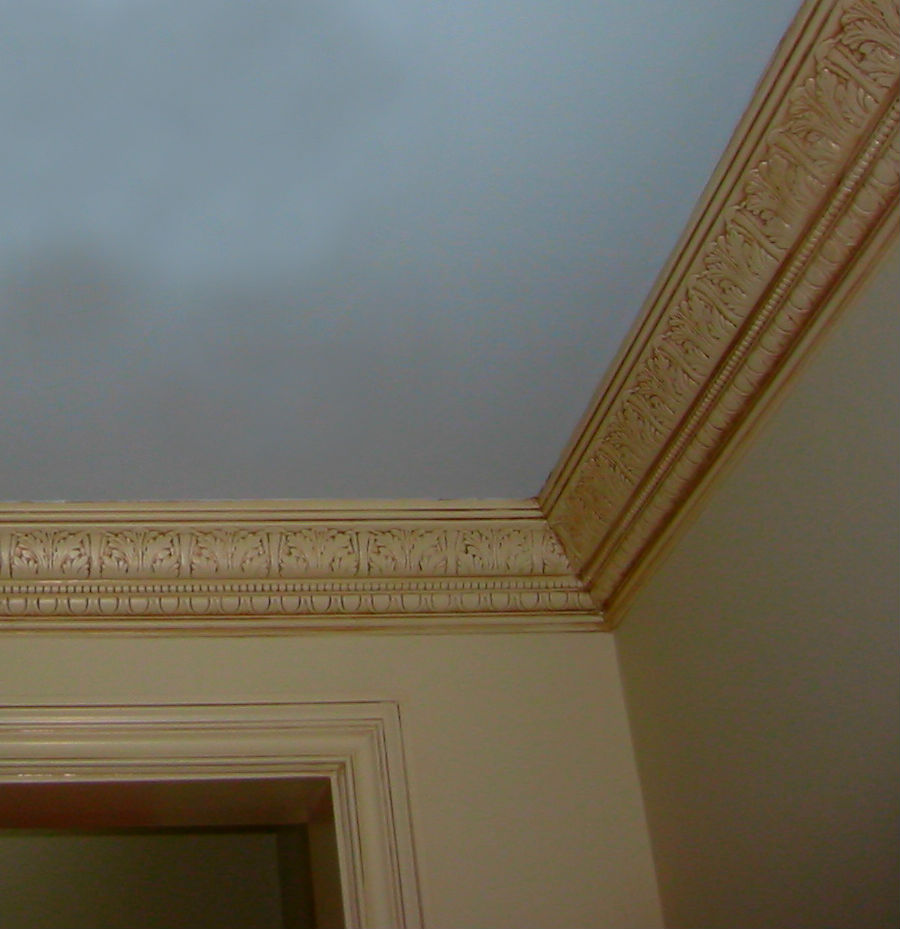 Рамки из потолочного плинтуса в интерьере на стене