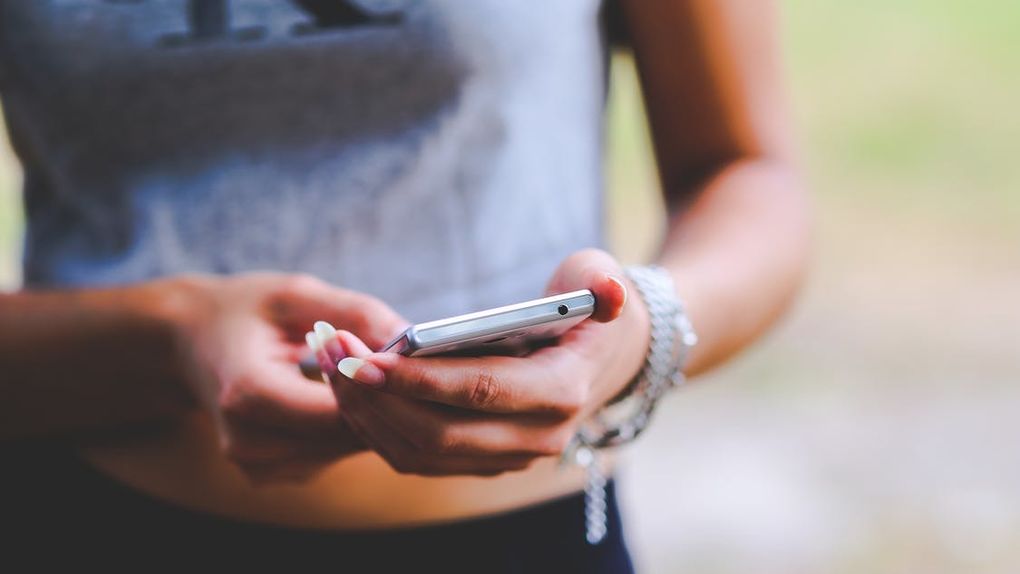 A girl is standing with a phone