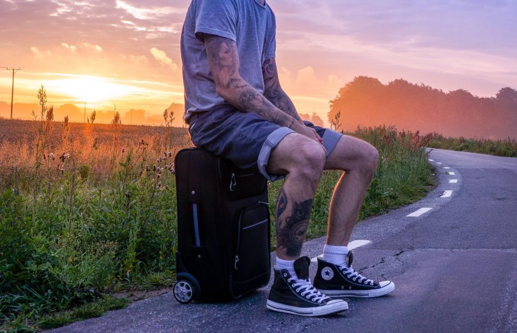 Guy is sitting on a suitcase