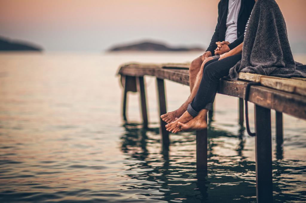 Two are sitting on the pier