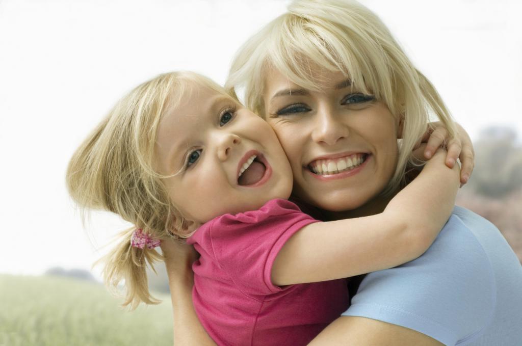 Woman hugs a little girl