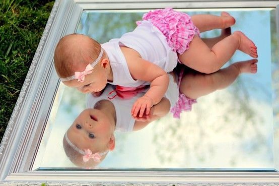 Малышка смотрится в зеркало