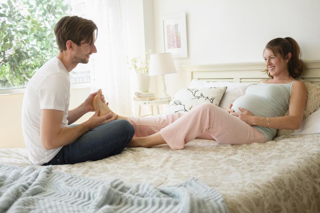 мужчина делает массаж ноги беременной женщине