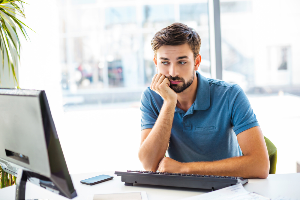 a man looks sadly at a computer