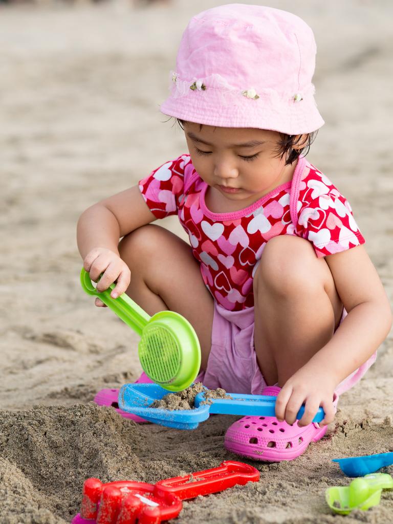 girl plays in the sand