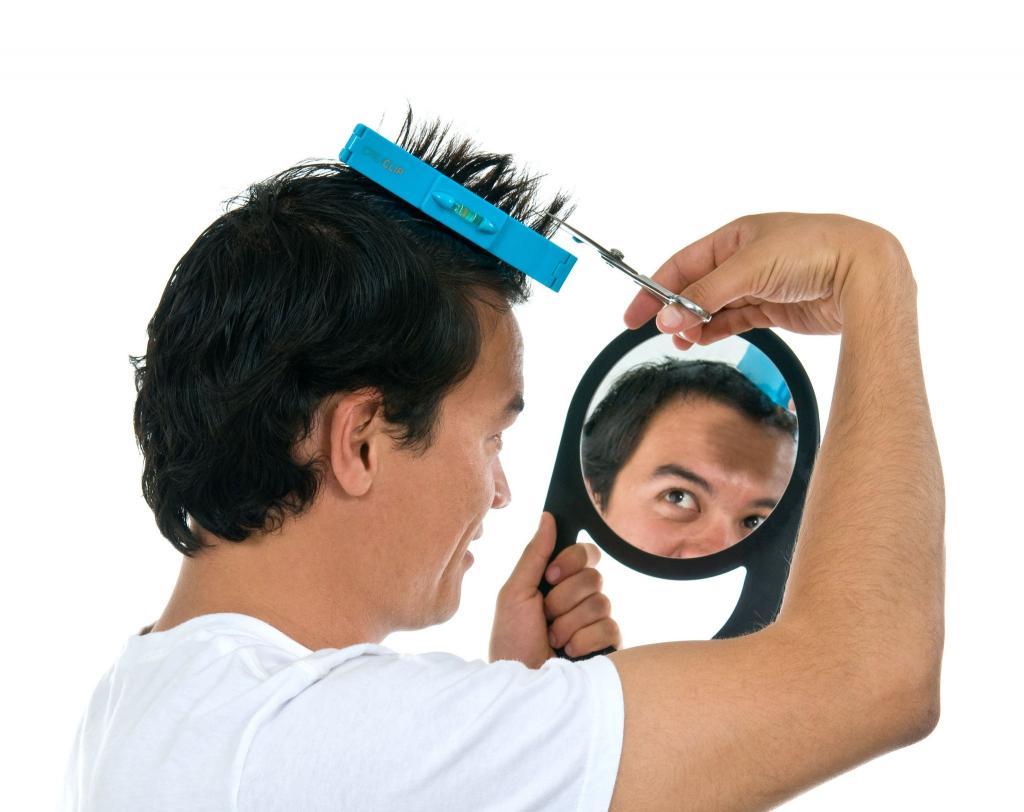мужчина стрижет себя перед зеркалом