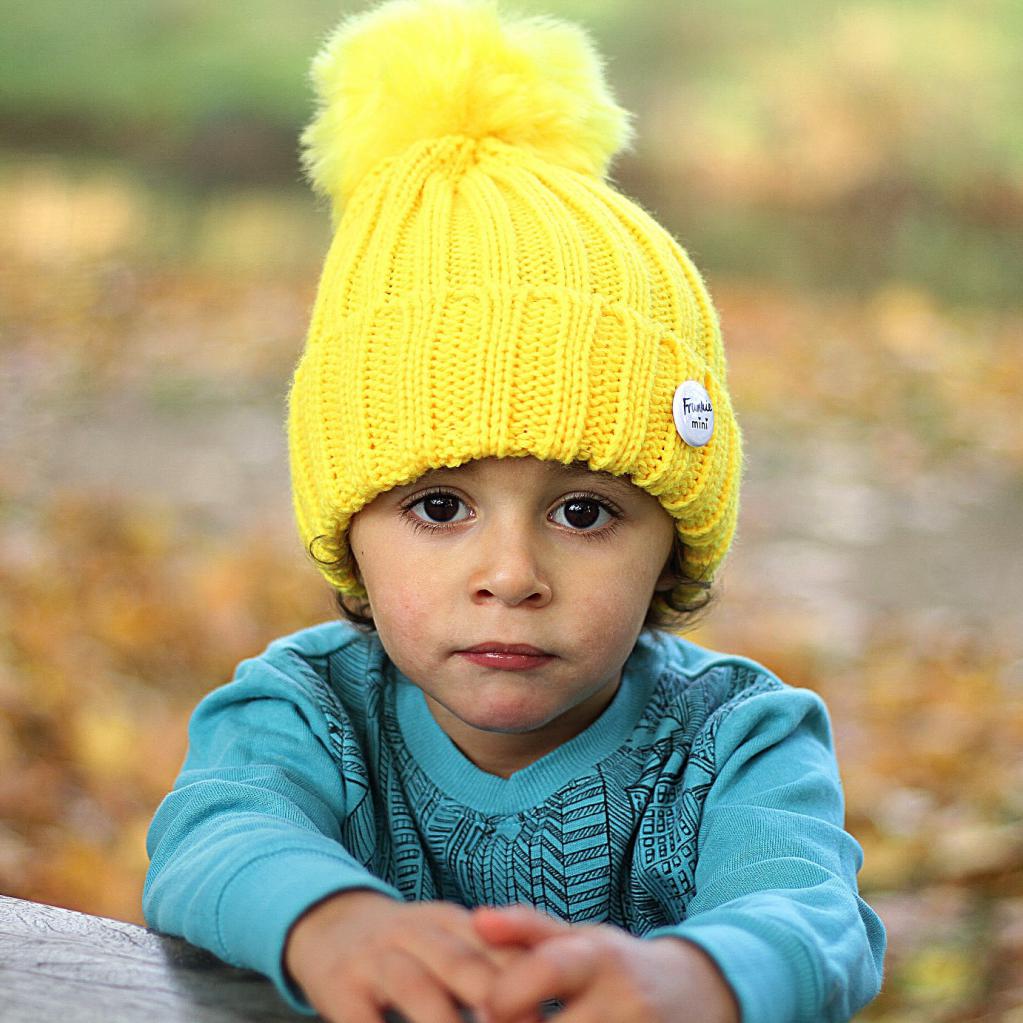 Ребенок в шапке с помпоном