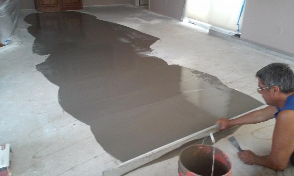 Выравнивание бетонного пола плиточным клеем под ламинат