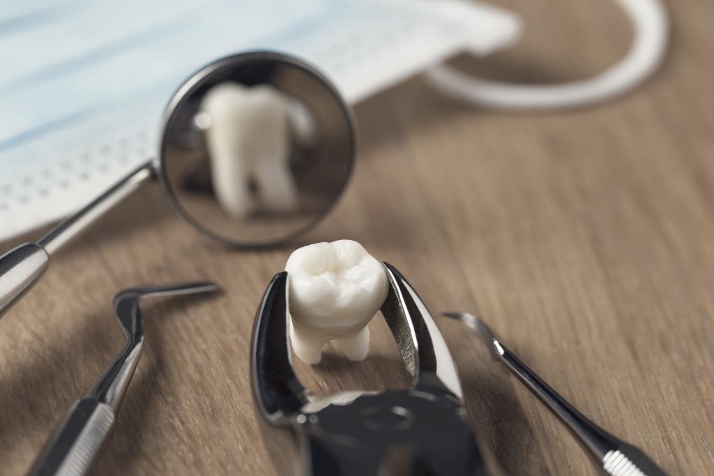 Зуб перед зеркальцем стоматолога