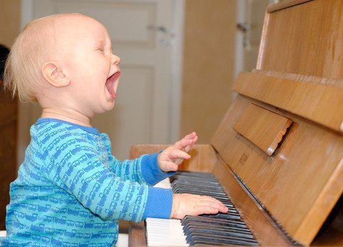 child sings at the piano