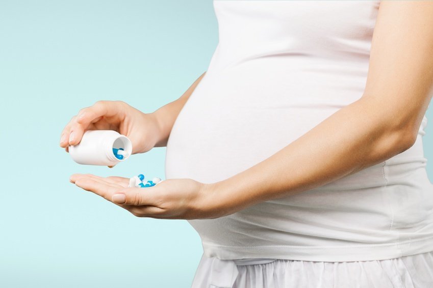 Беременная женщина принимает таблетки